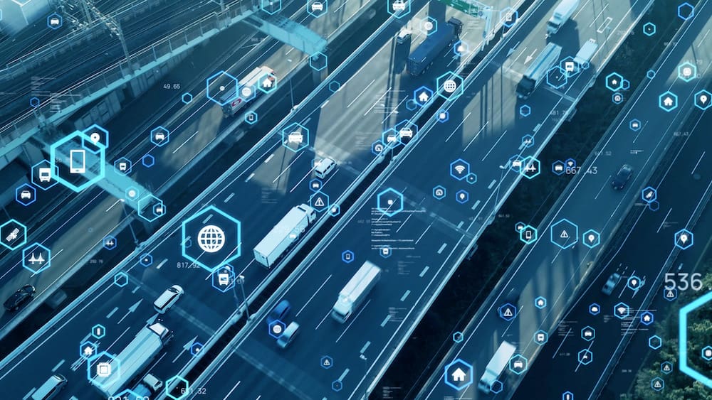 Highway with trucks and telematics technology icons overlay, representing the integration of telematics in modern transportation systems.